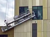 Storm winds batter workmen’s cradles into side of new hotel