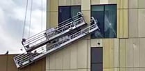 Storm winds batter workmen’s cradles into side of new hotel