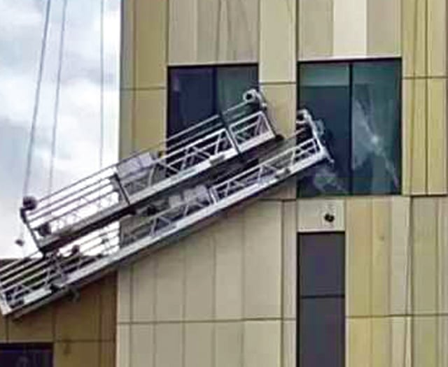 Storm winds batter workmen’s cradles into side of new hotel