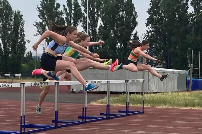 Woking's Nerys Tullett, right, competes in the women's 100m hurdles at the Linford Christie Stadium last weekend