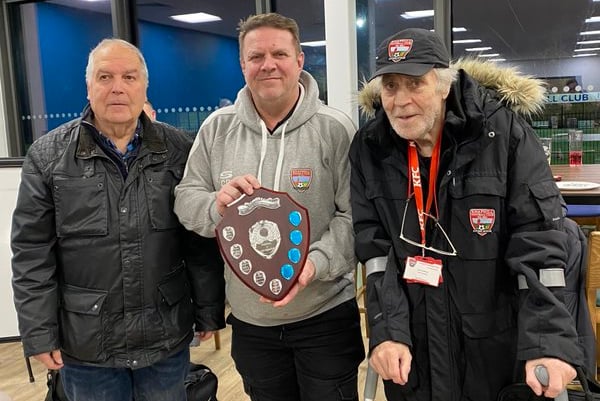Knaphill chairman Chris Drane, centre, and president Dave Holloway, right, receive the Dave Taylor Memorial Shield from its sponsor Mick Elliott after the Knappers’ 6-1 victory over the Sheers at the Eastwood Centre last Saturday (January 13, 2024) in the Cherry Red Records Combined Counties League