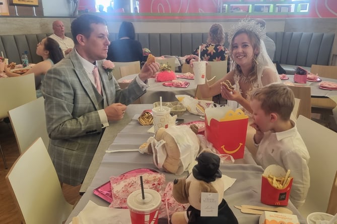 The bride and groom eating McDonald's on their wedding day