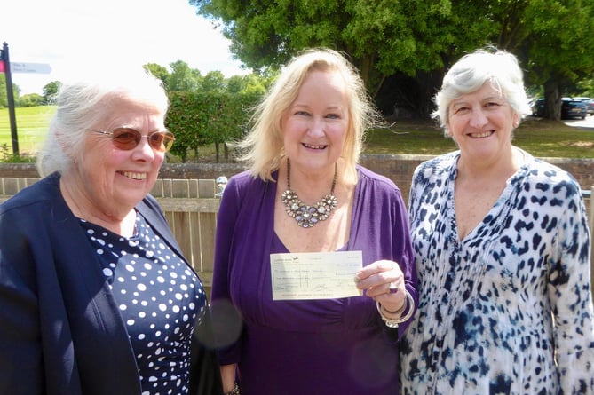 Tania Cantoni from Woking & Sam Beare Hospice receiving a cheque from Carol and Sue