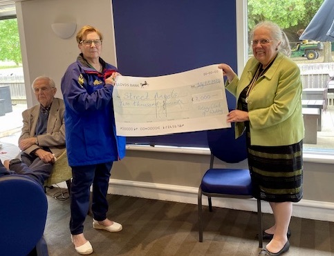 Barbara McManus of Woking Street Angels receiving a cheque from Carol Cheesman 