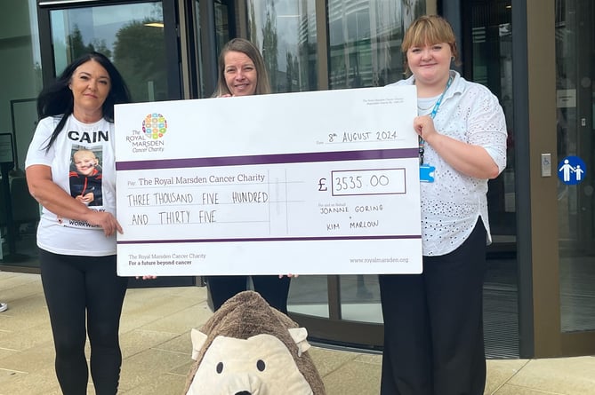 Cain Critcher's mum's cousins Joanne Brazil, left, and Kim Marlow hand over the cheque to the Royal Marsden Hospital