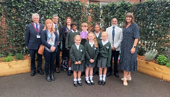 Some of the children of Knaphill School in front of their living wall with Mark Craven from the Lansbury Business Estate, Samantha Mills, Councillor Saj Hussain, Vikki Zeila, from the school PTA,  Councillor Hassan Akberali and Debbie Harrison, the head teacher